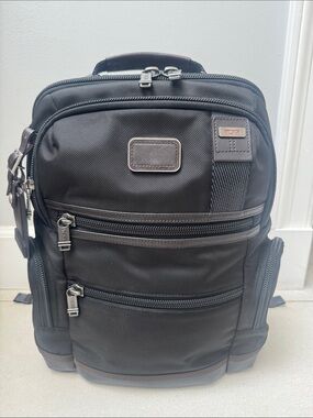 Tumi Alpha Bravo Backpack- 
Black Nylon Backpack with Brown Leather Trim